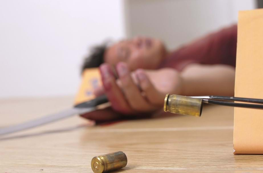 Crime scene with female victim and cartridge cases